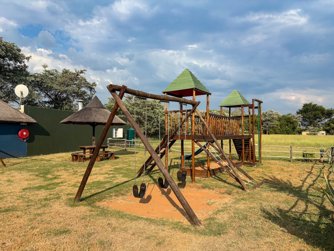 Empty wooden playground outdoors under sunny skies, ideal for kids' activities.